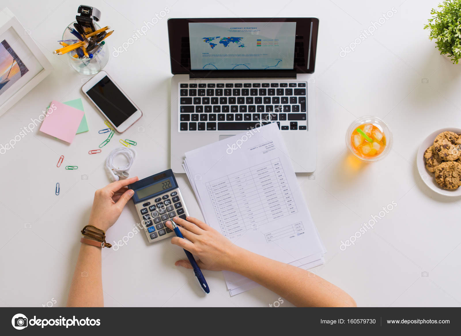 Accountant desk overhead flat lay — ledger, calculator, pen, and financial documents on natural wood desk